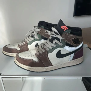Nike Air Jordans i flera färger - Säljer ett par Nike Air Jordans med en cool mix av färger som brunt, vitt och svart. Skorna har klassisk snörning och den ikoniska Nike-loggan på sidan. Perfekta för dig som vill ha en unik stil. Pris kan diskuteras. Original snören finns med