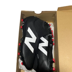 New Balance Tekela V4 Pro FG Leader In Classics - Svart - Snygga svarta fotbollsskor från New Balance med vit logga och röda dobbar. Skorna har en strumpliknande passform för extra komfort och stöd. Använda två gånger. Kommer med originallådan. Original pris 2699kr. Säljer för endast 999kr då storleken inte passade.