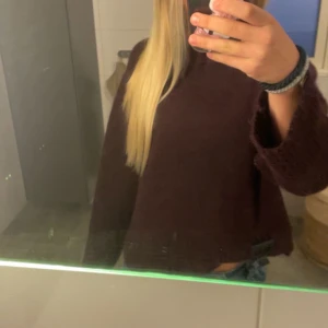 Mörkröd stickad tröja - Säljer en mysig mörkröd stickad tröja med långa ärmar. Perfekt för kyliga dagar och ger en avslappnad look. Passar bra till jeans eller leggings.