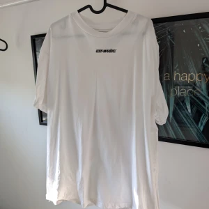 Vit t-shirt från Off-White - Säljer en vit t-shirt från Off-White med ett stort rött grafiskt tryck på baksidan och en liten logga på framsidan. T-shirten har en normal passform och är kortärmad. Perfekt för dig som gillar streetwear och vill ha något unikt i garderoben.