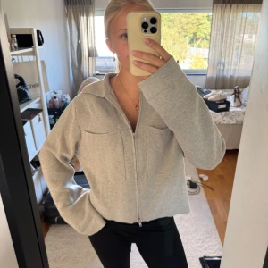 Grå overshirt med dragkedja - Snygg grå kofta med krage och två stora bröstfickor. 