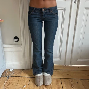 Lågmidjade bootcut jeans wrangler - Supersnygga lågmidjade bootcutjeans från wrangler i bra skick. Midjemått: 36,5cm. Innerbenslängd: 77cm