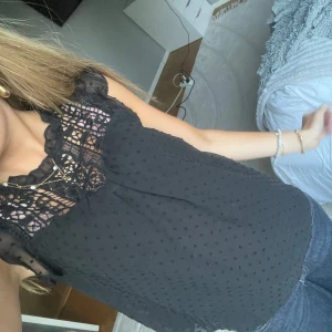 Svart blus med spets och prickar - Superfin