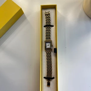 Guldig fyrkantig klocka från Bovou - Stilren klocka från Bovou i modellen form med fyrkantig urtavla i vitt och länkarmband i guld. Klockan har en klassisk design med metallarmband och levereras i original gul ask. Extra länkar medföljer för justering av storlek. Kostar ca 1400kr nypris. Skriv vid fler frågor🤗
