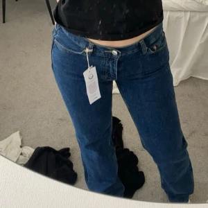 Blå lågmidjade jeans Gina - Snygga blå jeans från Gina med låg midja. Jeansen har en rak passform och är tillverkade i slitstarkt denimmaterial. Perfekta för dig som gillar en tidlös och avslappnad stil.