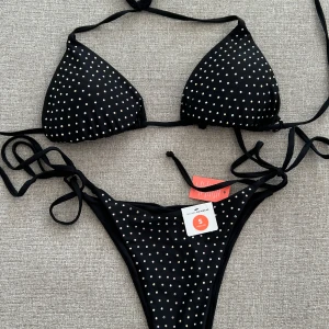 Svart bikini med strass - Superfin bikini med strass stenar, aldrig använd och med lappar samt hygien protection kvar . Bikini topp - Strl M Bikini Trosa - Strl S