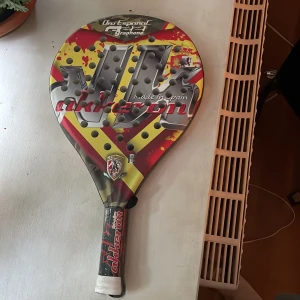 Oro Español Graphene Akkeron - Denna padelracket från Akkeron har en cool design med spanska färger och grafene-teknologi. Perfekt för dig som vill ta ditt spel till nästa nivå och sticka ut på banan! Racketen är tillverkad i Spanien och passar både nybörjare och erfarna spelare.