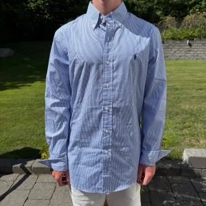 Blårandig Ralph Lauren skjorta - Vit/ blå randig Ralph lauren skjorta || Storlek M (Slim Fit) || Skjortan är i bra skick || Mitt pris 599kr || Modellen på bilden är 170cm och väger 62kg || Tveka inte på att höra av dig vid frågor eller funderingar 