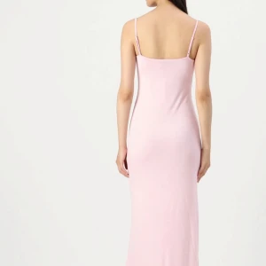 Ljusrosa långklänning med smala axelband - Säljer en stilren och enkel ljusrosa långklänning med smala axelband och figurnära passform. Klänningen har en rak siluett och ärmlös design som ger en clean och modern look. Perfekt för dig som gillar minimalistisk stil och mjuka färger, som visar formerna perfekt 