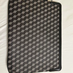 Datorfodral  - Säljer detta helt oanvända datorfodralet (finns prislapp kvar) den är svart med vita och bruna mönster och även en guldig dragkedja. Kan skicka fler bilder om det önskas 💕