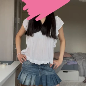 Levi's jeanskjol med plisserad kant - Supersnygg kort jeanskjol från Levi's med plisserad nederkant och rå kant. Kjolen har klassiska fickor fram och bak, knapp och dragkedja i midjan. Perfekt för dig som gillar en cool och avslappnad stil med denim.