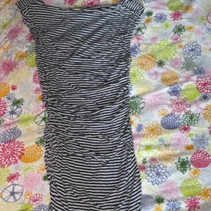 Svartvit randig kortklänning - Säljer en svartvit randig kortklänning med smickrande rynkade detaljer längs sidorna. Klänningen har en figurnära passform och är tillverkad i mjukt bomullsmaterial. Perfekt för dig som gillar en enkel men snygg look med lite edge.