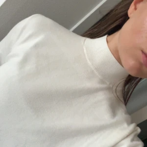 Vit polotröja med lång ärm - Säljer en stilren vit polotröja med hög krage och lång ärm. Tröjan har en clean look utan mönster eller detaljer och är perfekt för dig som gillar minimalistisk stil. Materialet känns mjukt och skönt mot huden, och passformen är normal. Perfekt att matcha med jeans eller kjol.