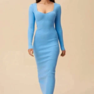 Blå långärmad klänning från Adoore - Säljer en snygg blå långklänning från Adoore med figurnära passform och långärmade ärmar. Klänningen har en fyrkantig urringning och är ribbad i materialet vilket ger en cool struktur. Perfekt för dig som gillar stilrena och trendiga plagg.