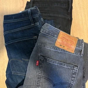 Levi's 501 och Jack & Jones jeans - Säljer flera par jeans från Levi's och Jack & Jones. Levi's 501 i grått med klassisk patch, samt mörkblå och svarta jeans. Jack & Jones jeans i svart, mörkblå och ljusblå tvätt, alla med snygga bakfickor och läderpatch. Perfekt för dig som gillar stilrena och tidlösa jeans.