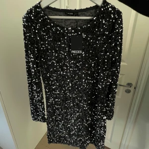 Svart glitter klänning från Pieces - Glittrig svart kortklänning från Pieces, klänningen har en lite lösare passform och passar perfekt inför t.ex nyår 