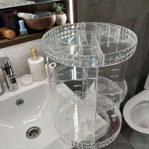 Roterande sminkställ  - Snyggt och praktiskt roterande sminkställ i transparent akryl med diamantmönstrad kant. Perfekt för att organisera smink som borstar, läppstift och ögonskuggor. 