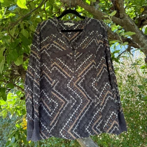 Odd molly blus  - Supersnygg långärmad skjorta från Odd Molly med bohemiskt mönster i grått, beige, brun och vit. Blusen har spetsdetaljer vid ärmslut och bröst, samt v-ringad hals. Tillverkad i mjuk bomull, perfekt för dig som gillar unika detaljer och coola prints. Storlek 4 som enligt deras storleksguide motsvarar en storlek L/XL, men jag tycker denna modell är liten i storlek.  Mycket fint skick, jag hittar inga synliga anmärkningar eller defekter. 