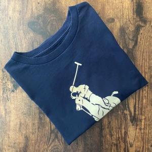 Polo Ralph Lauren T-Shirt - Polo Ralph Lauren t-shirt i mörkblått, storlek S. Stor logga framtill som ändrar färg i solen – blir orange/gul i värme! Unik detalj och riktigt snygg fit. Perfekt till sommarens outfits. Bra skick utan hål eller fläckar.