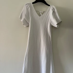Vit ribbad klänning från ONLY - Superfin vit ribbad klänning från ONLY med kort ärm, v-ringning och knytning i ryggen. Klänningen har en lätt A-linjeform och är i ett mjukt, stretchigt material som känns bekvämt. Perfekt för dig som gillar en enkel men stilren look. Pris kan diskuteras 💕💕