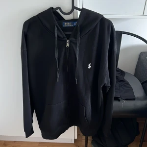 Svart hoodie från Polo Ralph Lauren XL - Säljer nu min helt nya polo stolt lauren zip tröja då den är för stor för mig kan ta byten storlek XL passar bra om man är 185cm