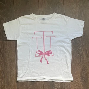 söt baby tee t-shirt med rosett - vit baby tee (t-shirt) i 100% bomull !!                            lik ”in print we trust”, har en rosa rosett på framsidan med extra detaljer, storlek xxs-xs si