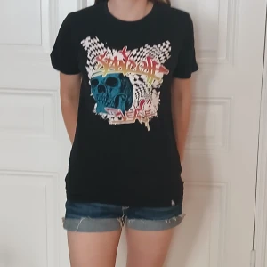 Svart t-shirt med dödskalle  - Svart t-shirt från Firefly med coolt tryck framtill: blå dödskalle, graffiti-text och schackrutigt mönster. Skön passform och klassisk rund hals. Perfekt för dig som gillar streetstyle och vill sticka ut med en edgy vibe. Tror egentligen att det är en herr tröja men jag är tjej så den sitter annorlunda på mig. Säljer då jag nästan aldrig använt den så den är i bra skick❤️