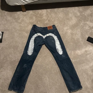 Evisu jeans - Säljer nu dessa feta evisu byxor med stort vit tryck bak, köpte dem i London förra året och alla bevis tyder på att byxorna är äkta. Kan tänkas bytas mot andra skor o kläder. Storleken är 32/34