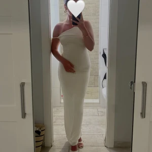 Vit långklänning med snörning - Klänning från Oh-polly med öppen rygg, i mycket bra skick då den endast är använd en gång. I storlek uk 6, men väldigt stretchig. Nypris: 800 kr. 