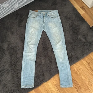 Ljusblå jeansbyxor från Dondup - Säljer ett par ljusblå jeansbyxor från Dondup med klassisk femficksdesign och snygga slitningar. Jeansen har raka ben och normal passform. Priset är inte hugget i sten. Säljer då jag inte använder dom.