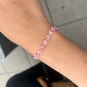 Sött pärlarmband med rosa blommor - Supergulligt armband med små rosa och vita pärlor formade som blommor. 