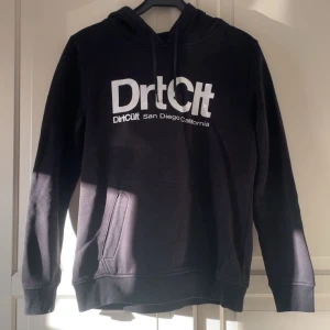 Svart hoodie från DirtCult XL - Jättefint svart hoodie från DirtCult i storlek XL med vit logga och klassiska loggan på. Den har huva, snörning och ficka framtill. Använd max 3 gånger. Dammodellen men funkar som unisex. Ganska liten i storleken!💕💕