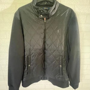 Polo Ralph Lauren Cardigan - Svart cardigan från Polo Ralph Lauren med quiltad framsida och släta ärmar. Jackan har två knapp fickor framtill. Klassisk logga broderad på bröstet. Perfekt för lite kallare sommarkvällar och vår och höst. Nypris 2300kr Fick den i födelsedagspresent använt fåtal gånger. Priset kan diskuteras.
