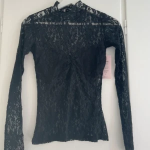 Svart spetsblus med lång ärm - Helt oanvänd spets topp från Nelly med prislapp kvar🥰