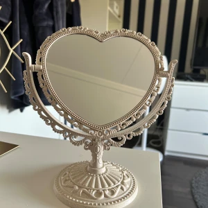 Hjärt formad spegel - En beige hjärt formad spegel som är sååå söt och spegeln går att skriva loss samt vrida på så perfect för att sminka säg med! Super söt!