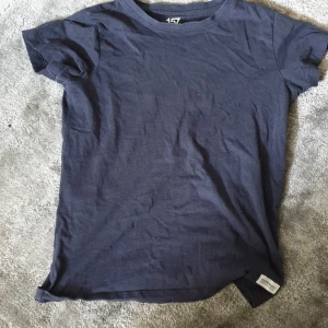 Mörkblå t-shirt från 157 Denim Makers - En basic mörkblå t-shirt från 157 Denim Makers med rund hals och korta ärmar. Skön passform och tillverkad i mjuk bomull, perfekt till jeans eller shorts. Liten vit etikett nertill med logga för en clean look.