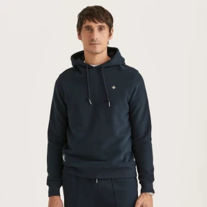 Mörkblå hoodie från Morris - Säljer en mörkblå hoodie från Morris med klassisk huva och snörning. Tröjan har en liten broderad logga på bröstet och ribbade muddar vid ärmslut och nederkant. Storlek L men passar även för dem med storlek M, liten i storlek.