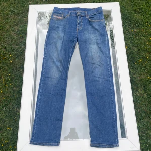 Diesel Jeans Straight Fit -  Säljer ett par Diesel jeans i straight fit med klassisk mellanblå tvätt. Storlek W30, straight fit (rak passform). Material med lätt stretch för bekväm passform. Jeansen är i fint begagnat skick, inga hål eller större slitage. Pris går att diskutera, bara aatt höra av sig vid minsta fudering!