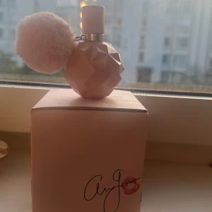 Ariana Grande Sweet Like Candy parfym - Säljer Ariana Grande Sweet Like Candy parfym i en ljusrosa, multifasetterad flaska med en fluffig rosa pompom. Flaskan är riktigt söt och har en modern design som sticker ut på hyllan. Kommer i originalkartong med signaturtryck och läppstiftsdetalj. Det är lite mer än halva flaskan kvar💕kommer med boxen💕