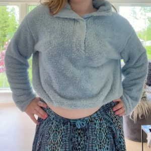 Ljusblå teddyjacka - Supermjuk och fluffig ljusblå teddytröja från H&M med halv dragkedja och hög krage. Perfekt för kyliga dagar och riktigt mysig att ha på sig. Tröjan har långa ärmar och en lite oversized passform. Den är lite sliten men ändå användbar. Skriv vid frågor💕💕skulle gissa på storlek M