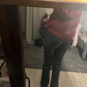 Svarta bootcut byxor i skinnlook BikBok - Snygga svarta byxor från BikBok i skinnimitation. Modellen är bootcut med normal passform och midwaist. Lite tråd som är på knappen på byxan som ni kan se på en av bilderna. Annars är dom i superbra skick 