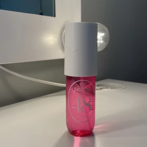 Sol de Janeiro Cheirosa 48 Perfume Mist - Fräsch och tropisk body mist från Sol de Janeiro, Cheirosa 48. Flaskan är cylinderformad i genomskinligt rosa plast med en stor vit kork. Doften har inslag av guava, solig orkidé och rosa mysk. Perfekt för dig som gillar söta och fruktiga dofter.