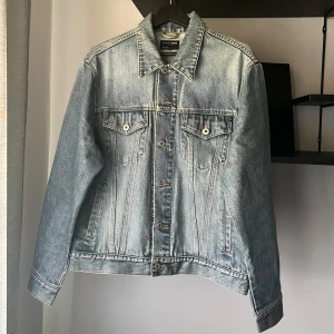 Ljusblå jeansjacka  - Snygg ljusblå jeansjacka från Goood Jeans med klassisk passform. Jackan har knappar framtill, två bröstfickor med lock och knapp samt sidofickor. Perfekt för dig som är mellan ca 175-185cm lång. 