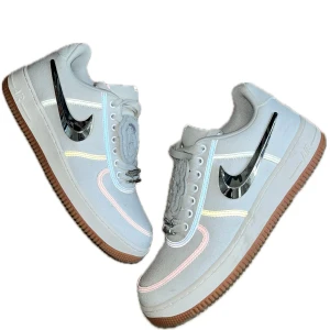 Nike x Travis Scott Air Force 1 - Nike x Travis Scott Air Force 1 i vitt tyg med utbytbara Swoosh-loggor. Skorna har brun gummisula, snörning och unika detaljer som broderad patch på plösen. Väldigt unika sneakers i riktigt bra skick. Storlek 45. Original låda och flera Swoosh-loggor följer med. Skicket baseras från bilderna. Skriv gärna vid frågor.