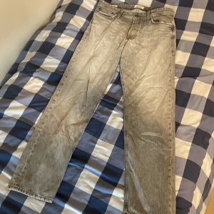 Grå loose fit jeans från Jack & Jones - Säljer ett par grå loose fit jeans från Jack & Jones, modell Chris. Jeansen har klassisk femficksdesign, raka ben och snyggt tvättad finish. Perfekta för dig som gillar en avslappnad och trendig look.