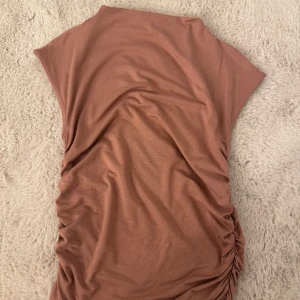 Elegant topp med rynkade sidor  - Säljer denna fina KORALL/ROSA toppen då den är för liten för mig. -Storlek xs men den passar definitivt till någon som bär större storlek, då den är från gina tricots ”soft touch” kollektion. Sitter väldigt snyggt när man väl tar på sig den! (Använd ca 3-4 gånger) 