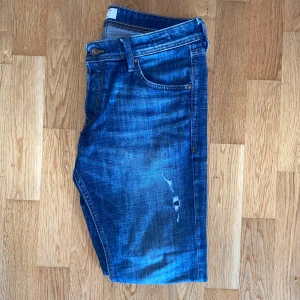 Blå jeans från Jack & Jones - Säljer dessa snygga jeans med slitningar från Jack and Jones. Storlek 32/30 Slim/Glenn i väldigt bra skick. 