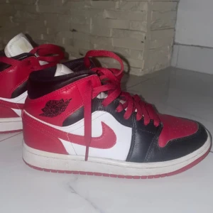 Nike Air Jordan 1 Chicago Highs - Säljer ett par ikoniska Nike Air Jordan 1 Highs i Chicago-färg. Skorna har röd, svart och vit färg med klassisk Jordan-logga på sidan. Tillverkade i skinn med röda snören och vit sula. Perfekta för dig som vill sticka ut med en tidlös sneaker. Skorna är i bra skick då jag bara har använt dem fåtalgånger eftersom att dem är lite stora på mig.