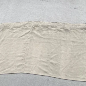 Beige linne gardinkappa i enkel stil - Enkel och stilren beige gardinkappa i linne. Perfekt för dig som gillar en clean och naturlig look. Tunt och luftigt material som ger en avslappnad vibe. Bredd: 242cm Längd: 52,5cm 