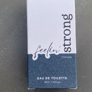 Feelin' Strong Eau de Toilette 30ml - Feelin' Strong Eau de Toilette för män från AQC. Flaskan är stilren i svart med blågrått lock och rymmer 30 ml. Parfymen har en modern design och är tillverkad av plast. Perfekt för dig som vill ha en fräsch och maskulin doft i en smidig förpackning.